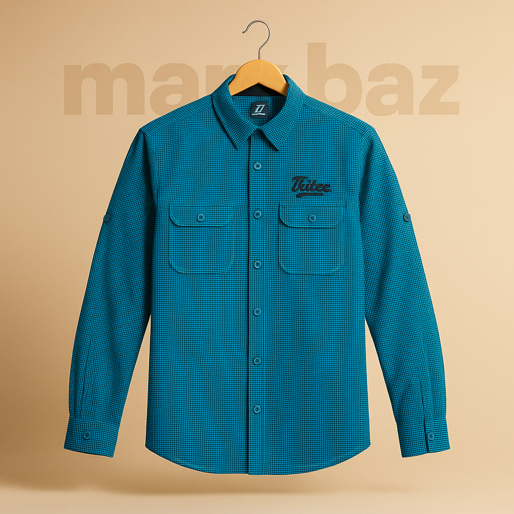 "پیراهن نخی مردانه Rocqose با طرح گلدوزی برجسته روی سینه – رنگ آبی فیروزه‌ای تیره و مشکی، سایز مدیوم، اورجینال و در حد آکبند مناسب استایل رسمی و روزانه"